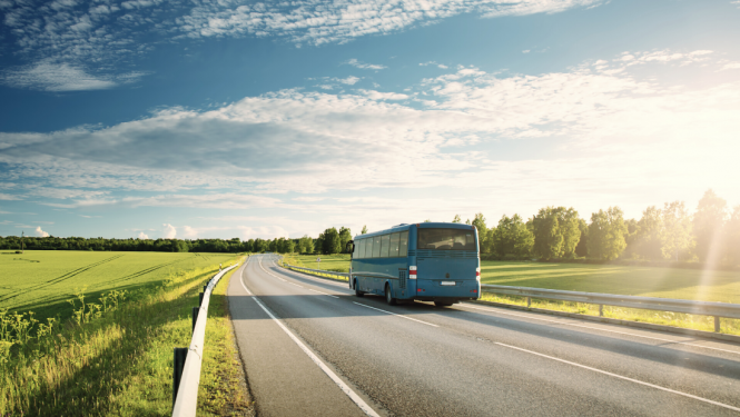Autobuss brauc pa asfaltētu lauku ceļu skaistā pavasara dienā